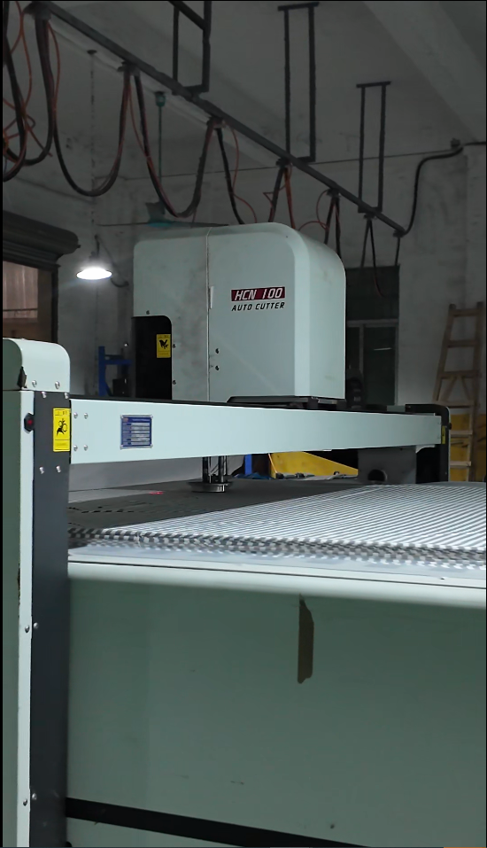 Automatic fabric cutter and stacked striped fabric in the HUAJUN cutting workshop