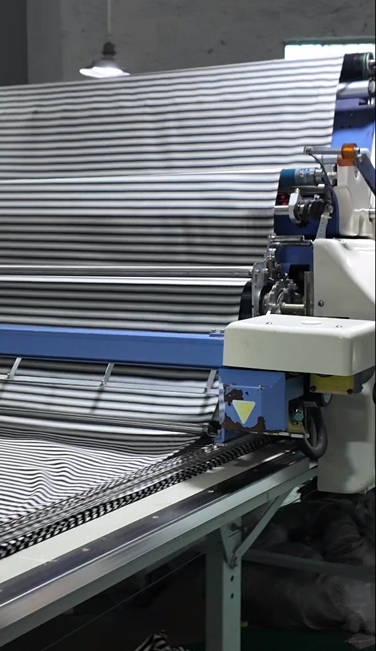 Striped fabric spread across the fabric preparation equipment at HUAJUN